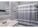 Stylish bathroom featuring a modern sink vanity and a shower with a gray and white striped curtain at 1740 Bouldercrest Se Rd, Atlanta, GA 30316