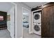 Hallway with laundry closet featuring stacked washer/dryer behind a sliding barn door, blending convenience with stylish design at 1740 Bouldercrest Se Rd, Atlanta, GA 30316