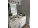 Bathroom vanity with dual sinks, white cabinets, and granite countertop at 2436 Moultrie Ct, Dacula, GA 30019