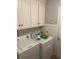 Bright laundry room with washer, dryer, and overhead cabinets at 2436 Moultrie Ct, Dacula, GA 30019
