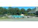 Community pool surrounded by seating areas and mature trees at 2436 Moultrie Ct, Dacula, GA 30019