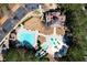 Aerial view showcasing the community pool, splash pad, clubhouse, and parking area surrounded by mature trees at 352 Southgate Dr, Locust Grove, GA 30248