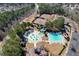 Aerial view showcasing the community pools, splash pad, tennis courts, and playground surrounded by mature trees at 352 Southgate Dr, Locust Grove, GA 30248