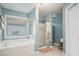Bathroom featuring a soaking tub, glass enclosed shower, and storage at 352 Southgate Dr, Locust Grove, GA 30248