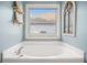 Bathroom soaking tub with chrome fixtures underneath a window at 352 Southgate Dr, Locust Grove, GA 30248