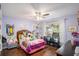 Bright bedroom featuring a ceiling fan, wood floors, and a window with natural light at 352 Southgate Dr, Locust Grove, GA 30248