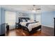 Inviting primary bedroom with a tray ceiling, hardwood floors, and natural light from large windows at 352 Southgate Dr, Locust Grove, GA 30248