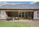 Covered patio with outdoor seating and brick accents with a view of the backyard at 352 Southgate Dr, Locust Grove, GA 30248