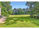 A spacious backyard featuring a lush green lawn, a patio with furniture, and mature trees at 595 Mcgarity Dr, Mcdonough, GA 30252