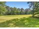 Spacious backyard with a vast green lawn and mature trees offering ample space for outdoor activities at 595 Mcgarity Dr, Mcdonough, GA 30252