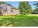 Beautiful backyard with a lush green lawn, mature trees, and a brick house exterior at 595 Mcgarity Dr, Mcdonough, GA 30252