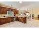 Spacious kitchen features wooden cabinets, stainless steel appliances, and tiled floors with a view to the dining area at 595 Mcgarity Dr, Mcdonough, GA 30252