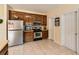 Kitchen with stainless steel appliances, wooden cabinets, and light tile flooring at 595 Mcgarity Dr, Mcdonough, GA 30252