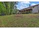 Expansive backyard featuring a covered deck, lush grass, and a wooded backdrop at 2582 Oak Bluff Dr, Dacula, GA 30019