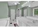 Bright and open bathroom showcasing a double vanity, soaking tub, and neutral color palette at 2582 Oak Bluff Dr, Dacula, GA 30019