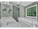 Serene bathroom with a large soaking tub, double vanity, and a window for natural light at 2582 Oak Bluff Dr, Dacula, GA 30019