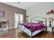 Cozy bedroom with a metal bed frame, wood floors, and large window for natural light at 2582 Oak Bluff Dr, Dacula, GA 30019