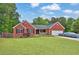 Attractive brick home with a well-kept lawn, lush landscaping, and convenient attached garage at 2582 Oak Bluff Dr, Dacula, GA 30019