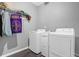 Functional laundry room featuring a washer, dryer, and shelving for ample storage at 2582 Oak Bluff Dr, Dacula, GA 30019