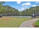 Fenced community tennis court surrounded by lush greenery, offering a great recreational space for residents at 2582 Oak Bluff Dr, Dacula, GA 30019