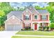 Charming two-story brick home with a well-manicured lawn and two-car garage at 5008 Bethpage Dr, Suwanee, GA 30024