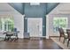 Inviting foyer features dark hardwood flooring, complemented by a vibrant blue accent wall and natural light from large windows at 5008 Bethpage Dr, Suwanee, GA 30024