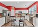 Charming kitchen with island, stainless steel appliances, white cabinets, and backsplash, ideal for culinary enthusiasts at 5008 Bethpage Dr, Suwanee, GA 30024