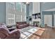 Spacious living room with a fireplace, large windows, and comfortable leather seating at 5008 Bethpage Dr, Suwanee, GA 30024