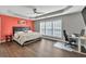 Spacious main bedroom with hardwood floors, a comfortable bed, and a well-lit work area at 5008 Bethpage Dr, Suwanee, GA 30024