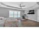 Spacious main bedroom with hardwood floors, tray ceiling, and a desk set up for work at 5008 Bethpage Dr, Suwanee, GA 30024