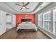 Spacious main bedroom featuring a tray ceiling, ceiling fan, hardwood floors, and large windows at 5008 Bethpage Dr, Suwanee, GA 30024