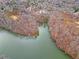 Picturesque aerial view of a waterfront property surrounded by bare trees and overlooking a serene lake at 120 Nezhat Pl, Atlanta, GA 30350