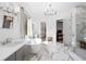 Beautiful primary bathroom with marble floors, freestanding tub, glass shower, and designer chandelier at 120 Nezhat Pl, Atlanta, GA 30350