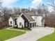 Elegant home with a spacious driveway, manicured lawn, and a sophisticated black and white exterior design at 120 Nezhat Pl, Atlanta, GA 30350