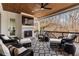 Covered porch with ceiling fan, fireplace, and comfortable seating area at 120 Nezhat Pl, Sandy Springs, GA 30350