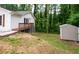 Backyard with a deck, storage shed, and lush green trees in the background at 1563 Brannon Sw Cir, Austell, GA 30106