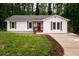 Charming one-story home with white siding, a red door, and lovely landscaping at 1563 Brannon Sw Cir, Austell, GA 30106