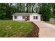 One-story home featuring fresh landscaping, wood shutters, and a charming red front door at 1563 Brannon Sw Cir, Austell, GA 30106