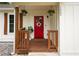 Inviting covered front porch with red door, hanging plants, and decorative wreath at 1563 Brannon Sw Cir, Austell, GA 30106