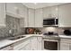 Updated kitchen showcasing granite countertops, gray subway tile backsplash, and stainless steel appliances at 2632 Peachtree Nw Rd # 203B, Atlanta, GA 30305