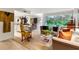 Open living area with a glimpse of the kitchen and lush greenery outside the window at 2632 Peachtree Nw Rd # 203B, Atlanta, GA 30305