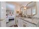 Stylish bathroom with double vanity, granite countertop, and gold framed mirrors across from bedroom at 4100 Springlake Cir, Buford, GA 30519
