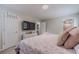 Comfortable bedroom featuring a TV, white dresser, and cozy pink patterned bedspread at 4100 Springlake Cir, Buford, GA 30519