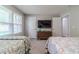 Bedroom with two beds, a dark wood dresser beneath a wall-mounted TV, with natural light from a window at 4100 Springlake Cir, Buford, GA 30519