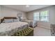 Serene bedroom featuring two beds, neutral tones, a tufted ottoman, and natural light streaming through the window at 4100 Springlake Cir, Buford, GA 30519