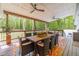 Relaxing covered deck showcasing forest view, wooden floors, ceiling fans, and ample seating for entertaining or unwinding at 4100 Springlake Cir, Buford, GA 30519