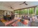 Spacious covered deck boasts wooded views, ceiling fans, stone accents, and comfortable seating, perfect for outdoor relaxation at 4100 Springlake Cir, Buford, GA 30519