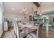 Bright dining area featuring an elegant chandelier, hardwood floors, and a dining table set for a lovely meal at 4100 Springlake Cir, Buford, GA 30519