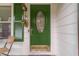Charming green front door featuring decorative glass and brass hardware at 4100 Springlake Cir, Buford, GA 30519