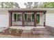 Inviting front porch featuring decorative pillars, a cozy seating area, and a charming front door at 4100 Springlake Cir, Buford, GA 30519